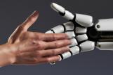 A human hand shaking hands with a robot hand