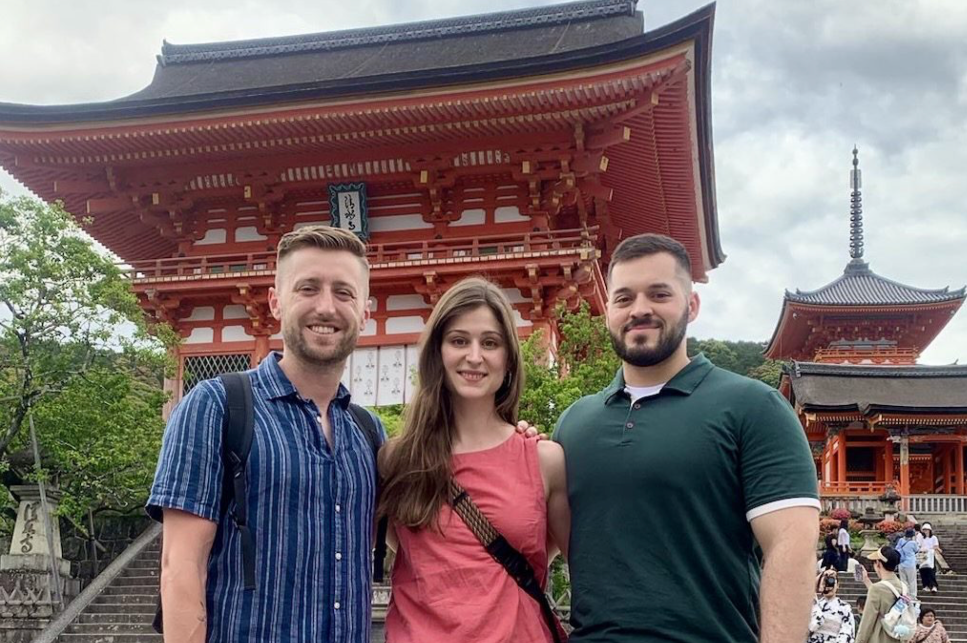 Three individuals pose for a photo in Japan