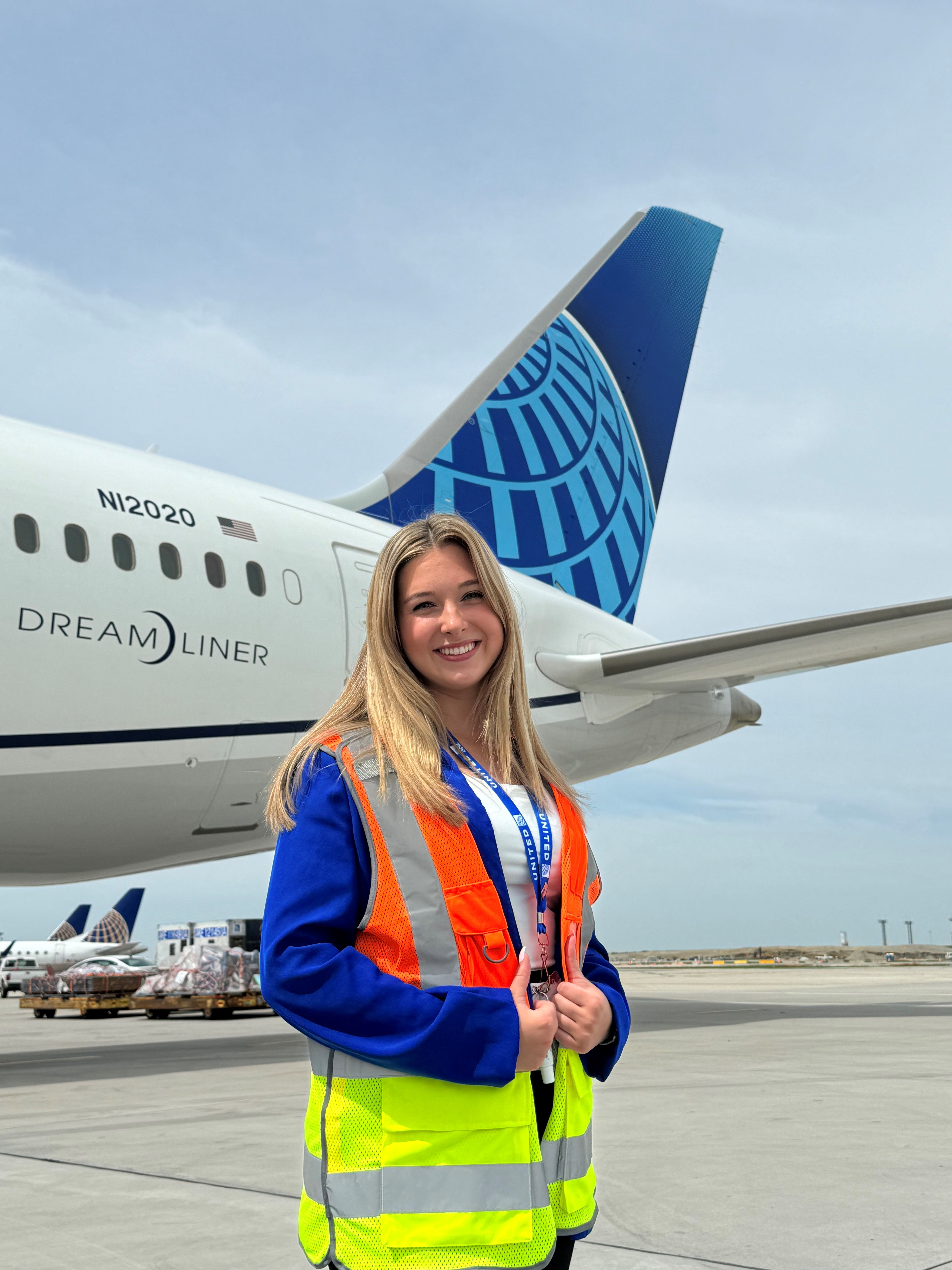 Bri Zahn poses for photo in front of United Airlines airplane