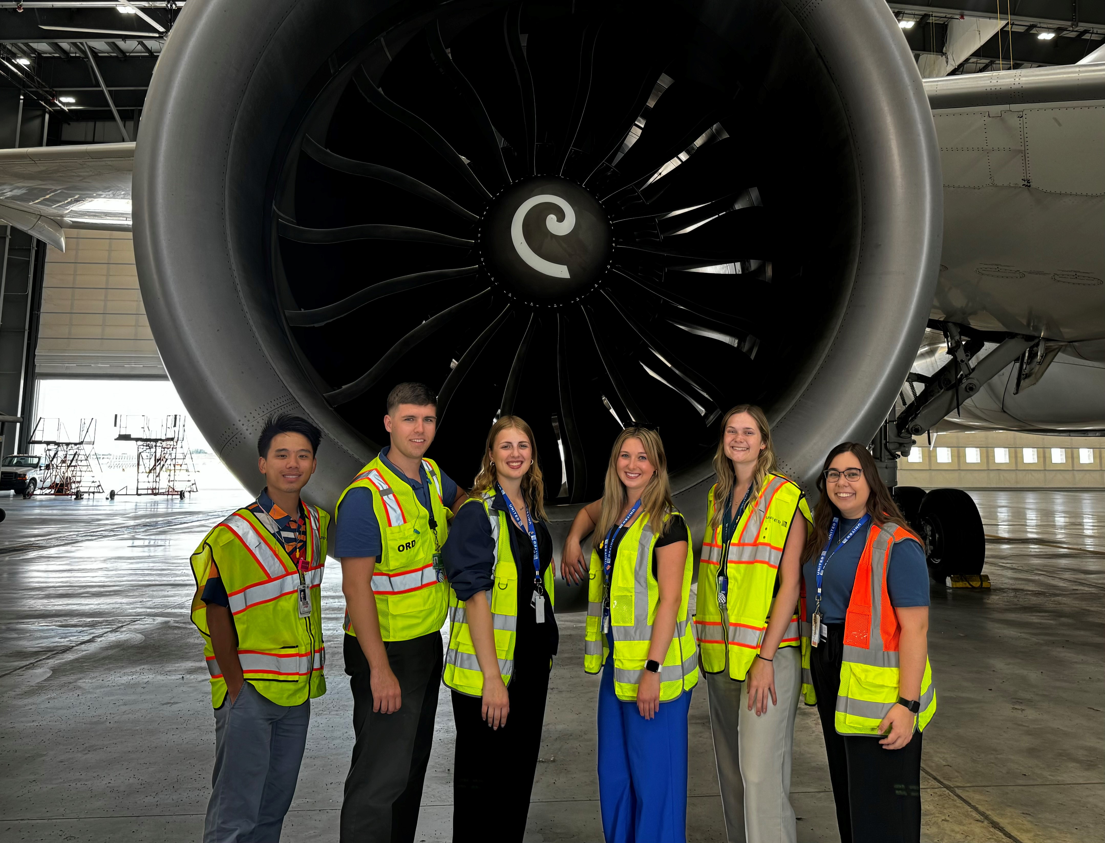 Group of United Airlines interns pose for a photo in front of airbus 