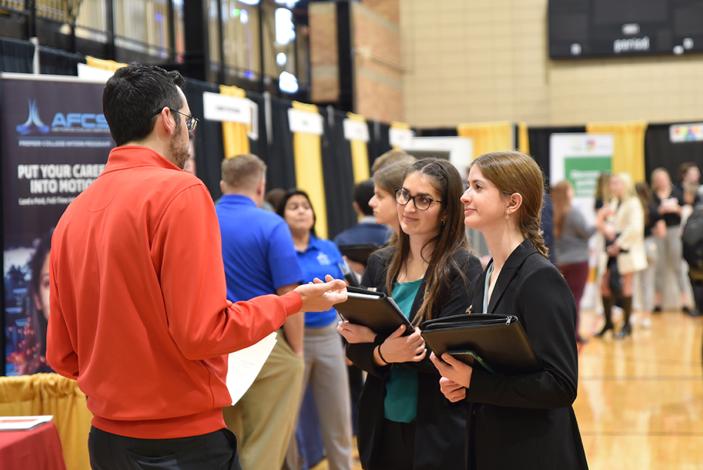 Vendor talks to students at career fair