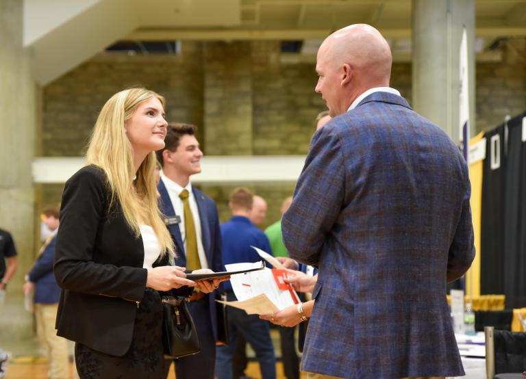 A woman and a man in suits talking