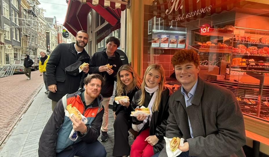 Students enjoying a sandwich outside t Kleine Slagertje Vet in Amsterdam