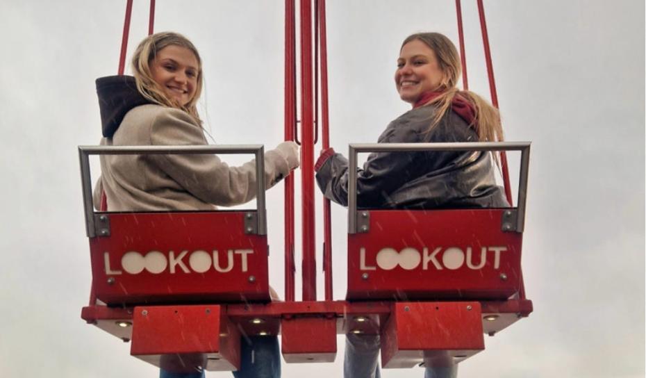 Two students on a swing overlooking Amsterdam