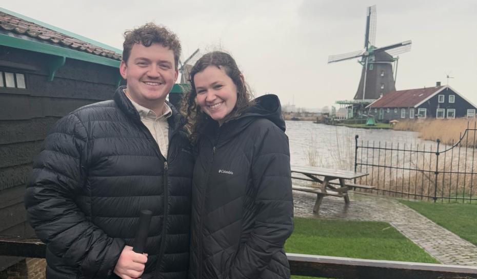 Two students in front of a windmill in Amsterdam
