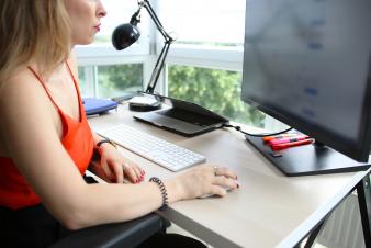 Image: Woman at a computer looking at the monitor.