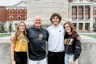 Photo of Brian Roberts and family in front of the columns.