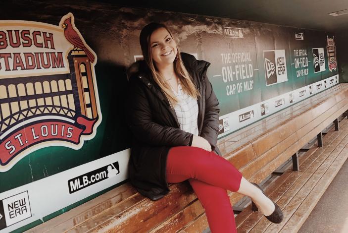 Image: Bailey Stamp sitting in the dugout at Busch Stadium in St. Louis.
