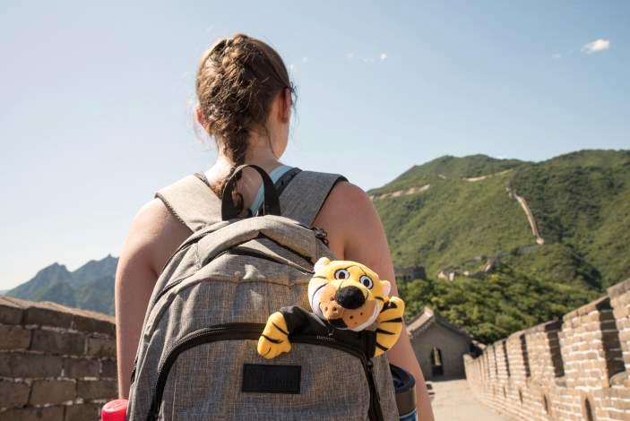 Student with Truman the Tiger in her backpack walking on the Great Wall of China