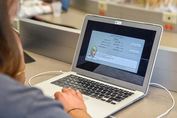 Photo of student playing the Trulaske Kaldi’s Sim in a retail marketing class 