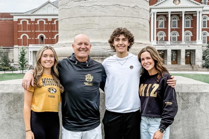 Photo of Brian Roberts and family in front of the columns.