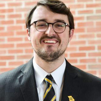 Image: Joseph Miller headshot in front of brick wall