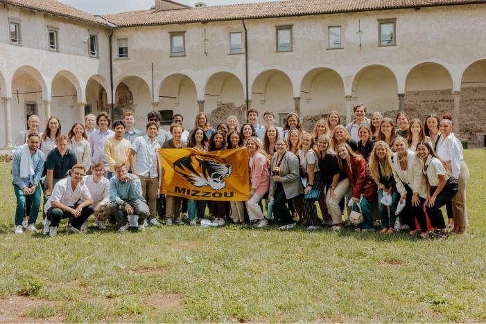 Students from the University of Missouri and the University of Bergamo hold a Mizzou Tigers flag on the Bergamo campus.