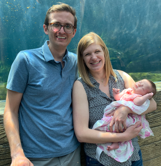 Andy Kiehl and his spouse, Sarah, pose with a photo of their daughter, Esther